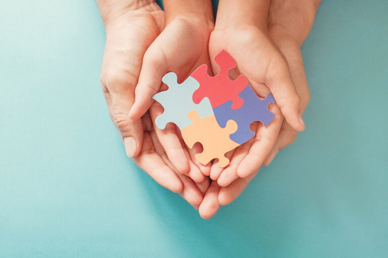 Hands of an adult and child holding colorful puzzles -Administration Of Children’s Services partnership for family support.