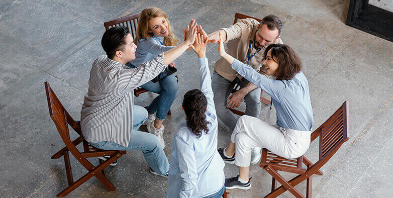 Chemical Dependency Treatment Program: Group of individuals in a circle, hands in the center, symbolizing support and recovery at LSA Recovery Inc.